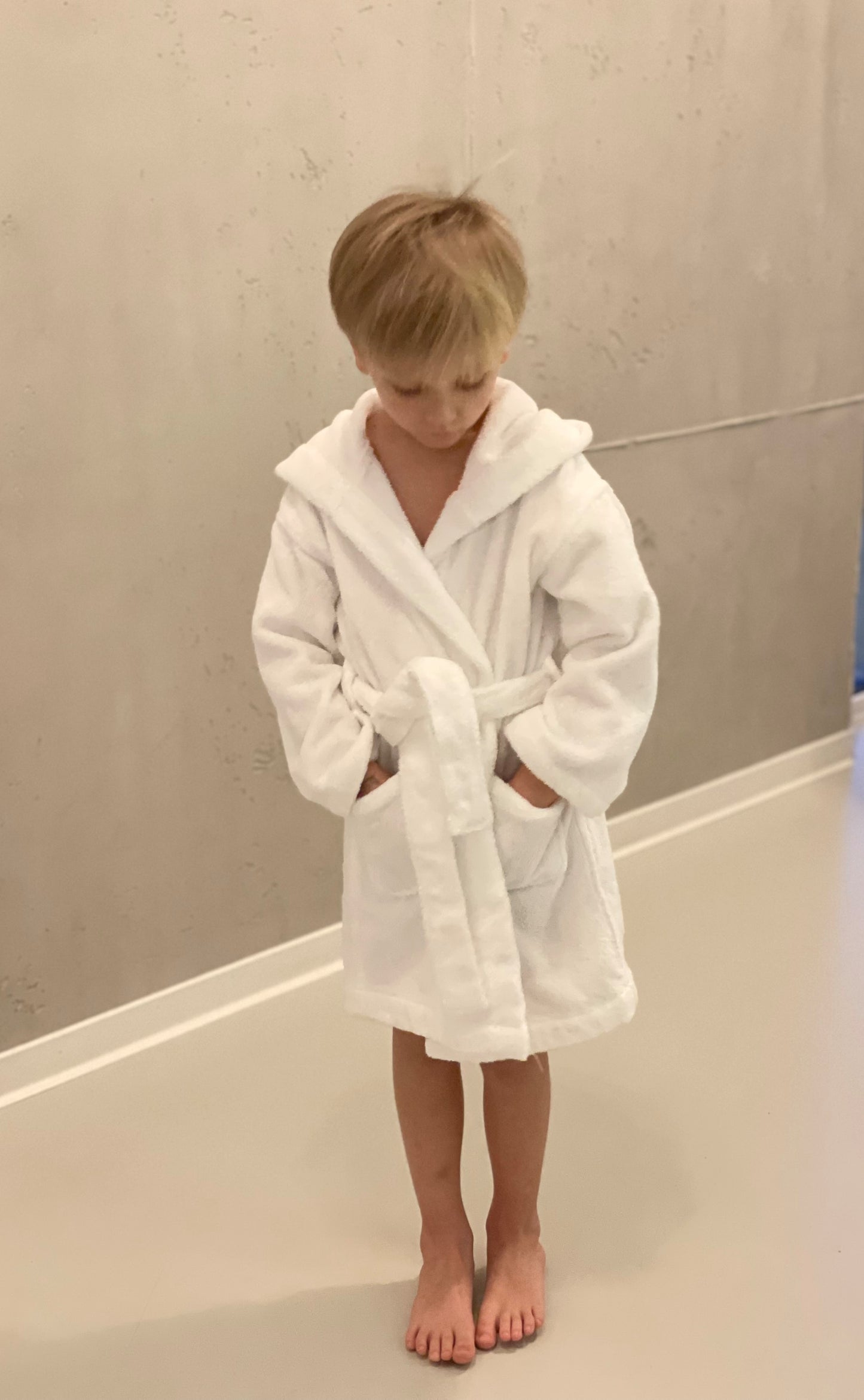 Tragebild Baumwoll Bademantel in weiß. Schlicht und kuschelig für Kinder von 3-6 Jahren.