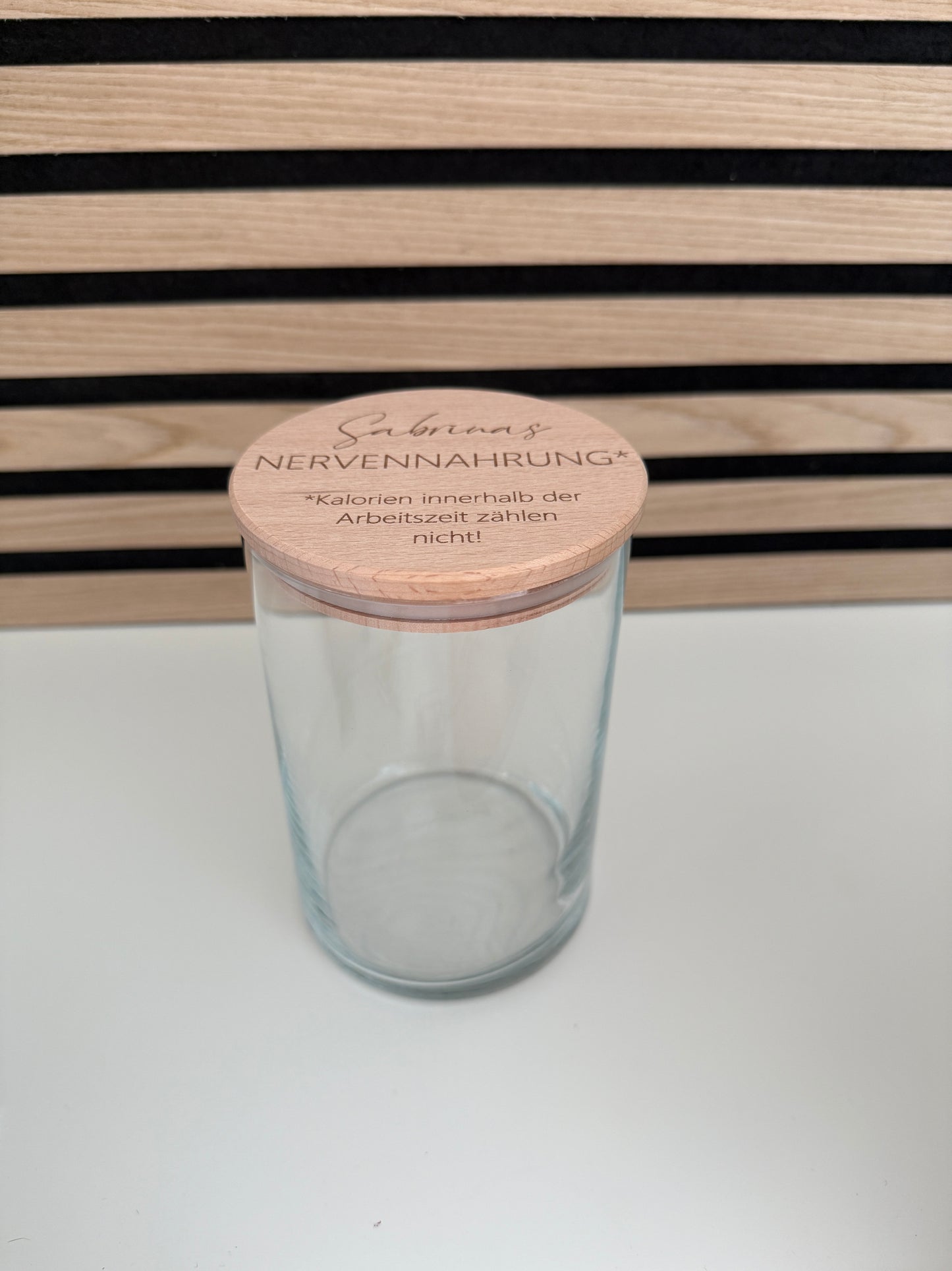 Glas mit Buchenholzdeckel.Der Deckel ist graviert mit dem Text: Sabrinas Nervennahrung- Kalorien während der Arbeitszeit zählen nicht. Das Glas kann mit beliebigem Inhalt befüllt werden und die Gravur mit Namen personalisiert.